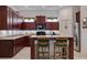 Traditional kitchen features dark wood cabinets, granite counters, and a two-stool breakfast bar at 205 Bengal Cir, Oldsmar, FL 34677