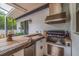 Well-equipped outdoor kitchen featuring a built-in grill, sink, and refrigerator, ideal for outdoor cooking at 205 Bengal Cir, Oldsmar, FL 34677