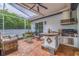 Charming screened-in patio features an outdoor kitchen, comfortable seating, and a tranquil garden view at 205 Bengal Cir, Oldsmar, FL 34677