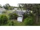 Backyard view showcasing a screened-in pool enclosure, mature landscaping, and a storage shed at 5728 Colonial Dr, New Port Richey, FL 34653