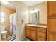 Cozy bathroom with wooden cabinets, a shower with patterned curtain, and tile flooring at 5728 Colonial Dr, New Port Richey, FL 34653