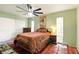 Spacious bedroom with a large ceiling fan, two windows, and colorful decor at 5728 Colonial Dr, New Port Richey, FL 34653