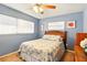 Comfortable bedroom with light blue walls, a wood-framed bed, and natural lighting from multiple windows at 5728 Colonial Dr, New Port Richey, FL 34653