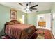 Bedroom with view to bathroom, ceiling fan, and light green paint at 5728 Colonial Dr, New Port Richey, FL 34653