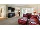 Carpeted living room with a large television, comfortable leather seating, and sliding glass doors to the outside at 5728 Colonial Dr, New Port Richey, FL 34653