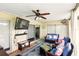 Enclosed patio with tile flooring, ceiling fan, mounted television, and comfortable blue wicker furniture set at 5728 Colonial Dr, New Port Richey, FL 34653