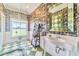 Elegant bathroom boasting designer wallpaper, vanity, mirror, glass enclosed shower, and green-tile floors at 15200 Rawls Rd, Sarasota, FL 34240