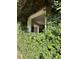 Exterior home view highlighting the overgrown greenery and unique architectural details, providing an enchanted feel at 15200 Rawls Rd, Sarasota, FL 34240