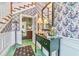 Charming foyer with floral wallpaper, bright green tile floor, console table, and a glimpse into other rooms at 15200 Rawls Rd, Sarasota, FL 34240