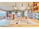 A well-lit kitchen featuring a double sink, pendant lights, and floral wallpaper at 15200 Rawls Rd, Sarasota, FL 34240