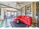 A spacious living room offers unique checkered floors, built-in shelves, and a bright red sofa at 15200 Rawls Rd, Sarasota, FL 34240