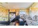 The main bedroom showcases patterned wallpaper, a four-poster bed, and sitting area near the windows at 15200 Rawls Rd, Sarasota, FL 34240