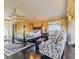 A spacious main bedroom has a sitting area, patterned wallpaper, and a luxurious four-poster bed at 15200 Rawls Rd, Sarasota, FL 34240