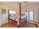 Bright main bedroom with a four-poster bed, hardwood floors, and access to an outdoor area at 15200 Rawls Rd, Sarasota, FL 34240