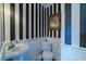 Stylish powder room with black and white striped wallpaper, pedestal sink, and a decorative gold-framed mirror at 15200 Rawls Rd, Sarasota, FL 34240
