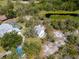 Aerial view of a home with a screened pool, surrounded by lush greenery and a private pond at 10230 289Th E St, Myakka City, FL 34251