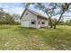 Detached garage with a modern design, set on a spacious lawn and surrounded by mature trees at 10230 289Th E St, Myakka City, FL 34251
