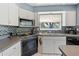 Well-equipped kitchen featuring stainless steel appliances, patterned backsplash, and white tiled flooring at 10230 289Th E St, Myakka City, FL 34251