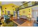 Bright living room with spiral staircase, piano, fireplace, and soaring ceilings at 10230 289Th E St, Myakka City, FL 34251