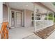 Covered front porch features a ceiling fan, seating, and a decorative front door at 10230 289Th E St, Myakka City, FL 34251