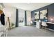 Bright bedroom features a large window, gray carpet, two desks, and a blue accent wall with contemporary art at 10434 Tucker Rd, Weeki Wachee, FL 34613