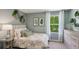 Comfortable bedroom with a green and white color scheme, soft lighting, and natural light from the window at 10460 Tucker Rd, Weeki Wachee, FL 34613