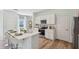 Bright kitchen featuring white cabinets, a large island, and modern appliances for a stylish and functional space at 10460 Tucker Rd, Weeki Wachee, FL 34613