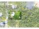 Aerial view of a well-maintained home surrounded by lush greenery, a private yard, and ample parking at 304 Highland St, Brooksville, FL 34601