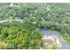 Aerial view showing a home nestled among trees with neighborhood surroundings at 304 Highland St, Brooksville, FL 34601