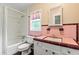 Vintage pink bathroom with a shower-tub combo, toilet, and vanity at 304 Highland St, Brooksville, FL 34601