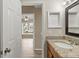 Well-lit bath with granite vanity and a view to the bedroom with a ceiling fan and large window at 14150 Prospect St, Spring Hill, FL 34609