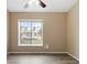 Vacant room features a large window and neutral paint, with wood-look flooring at 14150 Prospect St, Spring Hill, FL 34609