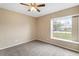 Neutral bedroom features a ceiling fan and a large window providing natural light at 14150 Prospect St, Spring Hill, FL 34609