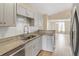 This kitchen shows granite counters, stainless appliances, tile backsplash and light wood floors at 14150 Prospect St, Spring Hill, FL 34609