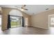 Spacious living room with wood floors, vaulted ceilings, and sliding glass door to the backyard at 14150 Prospect St, Spring Hill, FL 34609