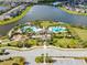 Breathtaking aerial view of the Belmont community pool, amenity center, and surrounding lake and residences at 14347 Easy Goer St, Ruskin, FL 33573