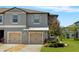 Charming townhome showcasing gray exterior, front yard, and two-car attached garages at 14347 Easy Goer St, Ruskin, FL 33573