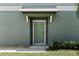 Inviting front entry showcasing a green door, gray siding, and a covered porch at 14347 Easy Goer St, Ruskin, FL 33573