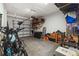 A well-lit garage featuring an automatic door, bikes, and storage shelves at 14347 Easy Goer St, Ruskin, FL 33573