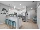 Bright kitchen features white cabinets, stainless steel appliances, breakfast bar with blue chairs, and tile flooring at 14347 Easy Goer St, Ruskin, FL 33573