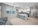 Open-concept kitchen with tile floor, white cabinets, stainless appliances, breakfast bar and large window at 14347 Easy Goer St, Ruskin, FL 33573