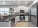 Modern kitchen showcasing white cabinets, granite counters, stainless appliances, and tile floors at 14347 Easy Goer St, Ruskin, FL 33573