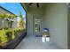 View of a screened porch with a doorway, overlooking lush landscaping and nearby building at 14347 Easy Goer St, Ruskin, FL 33573