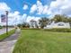 Inviting street view showcases lush landscaping and the Belmont community entrance sign under a sunny sky at 14347 Easy Goer St, Ruskin, FL 33573