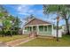 Charming single-story home featuring a welcoming front porch, green siding, and well-maintained landscaping at 2715 14Th N Ave, St Petersburg, FL 33713