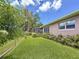 Fenced backyard featuring lush green lawn, an enclosed patio, and manicured landscaping at 1137 Indian Rocks S Rd, Largo, FL 33770