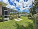 Beautiful backyard with lush green grass, a screened patio, and a grill for outdoor entertaining at 1137 Indian Rocks S Rd, Largo, FL 33770