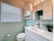 Charming bathroom with unique mint green tile, white vanity, and a mirrored medicine cabinet at 1137 Indian Rocks S Rd, Largo, FL 33770