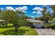 Charming home featuring a well-manicured lawn, mature trees, and a welcoming driveway at 1137 Indian Rocks S Rd, Largo, FL 33770