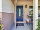 Inviting entryway featuring a stylish blue front door, decorative welcome mat, and well-manicured plants at 1137 Indian Rocks S Rd, Largo, FL 33770